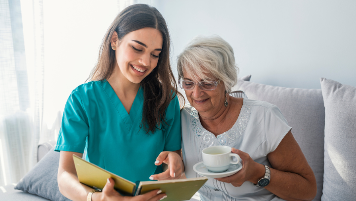 old lady reading with caregiver