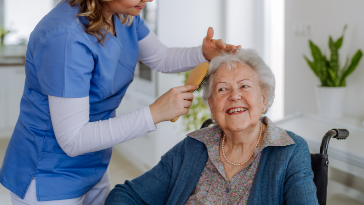 caregiver combing the hair of an old lady 