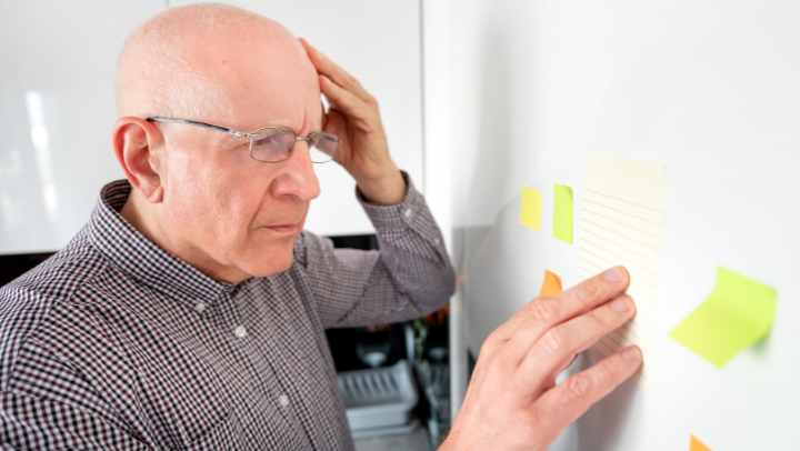 an old men trying to read a paper on a wall